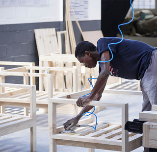 Man sanding pine patio furniture